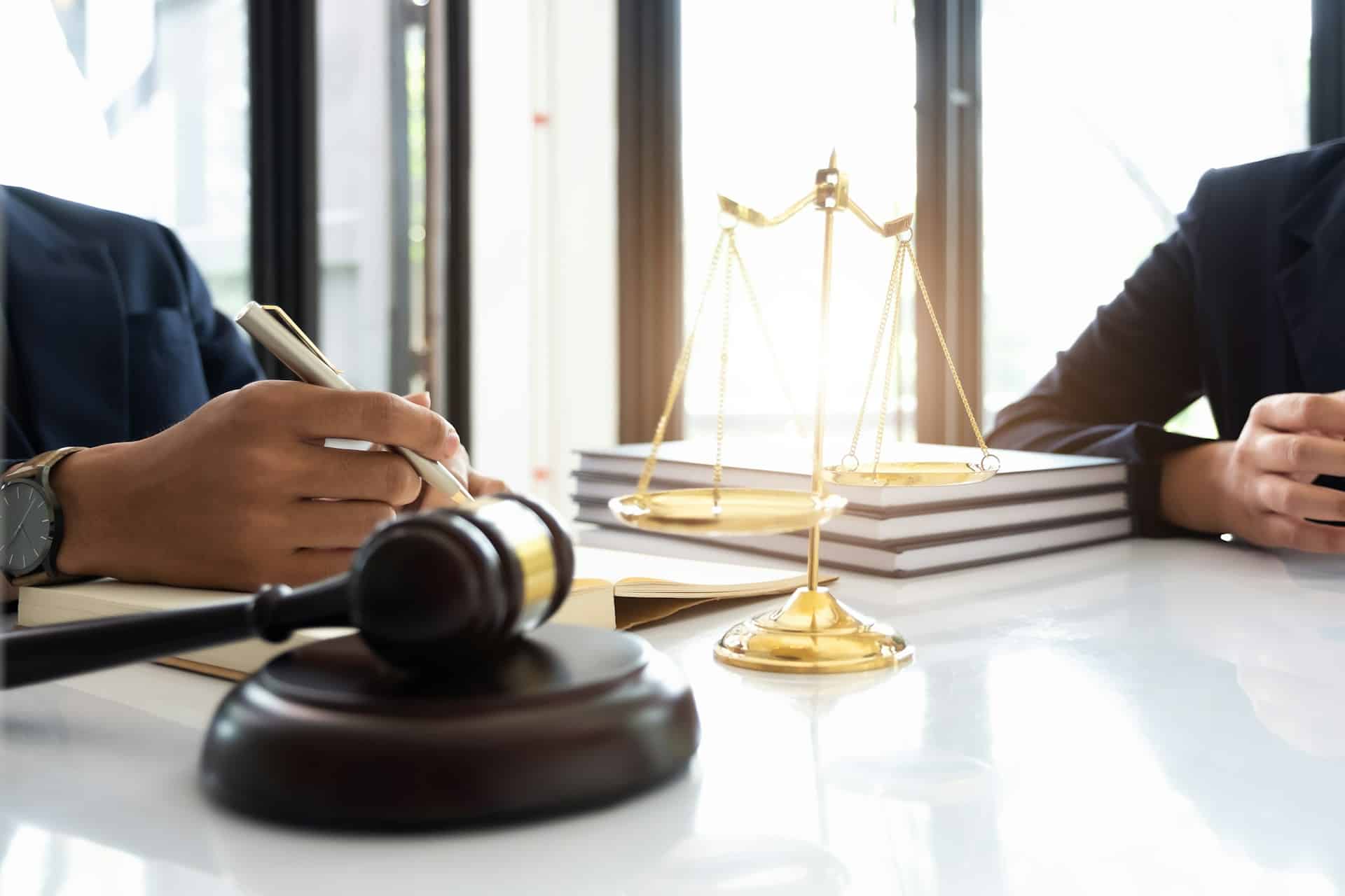 a person sitting at a table with a gavel and a book